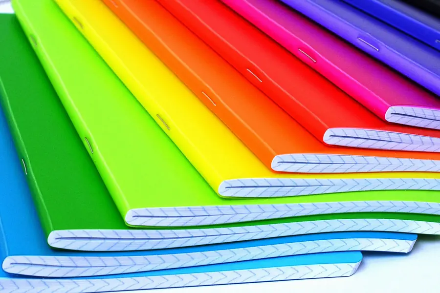 Stack of exercise notebooks with brightly coloured covers